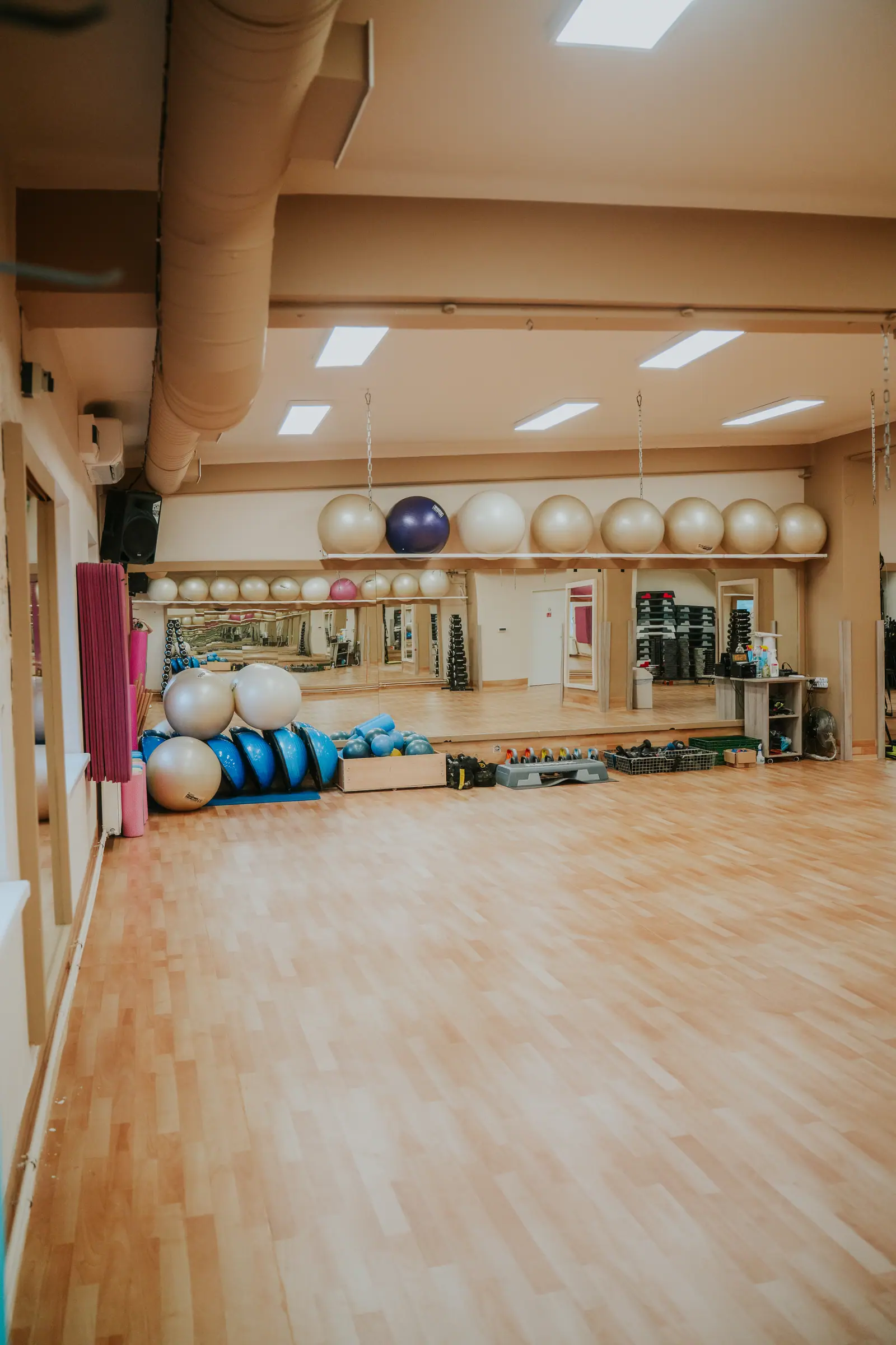Aerobik terem fitneszlabdákkal, BOSU labdákkal és step padokkal a tükörfal előtt