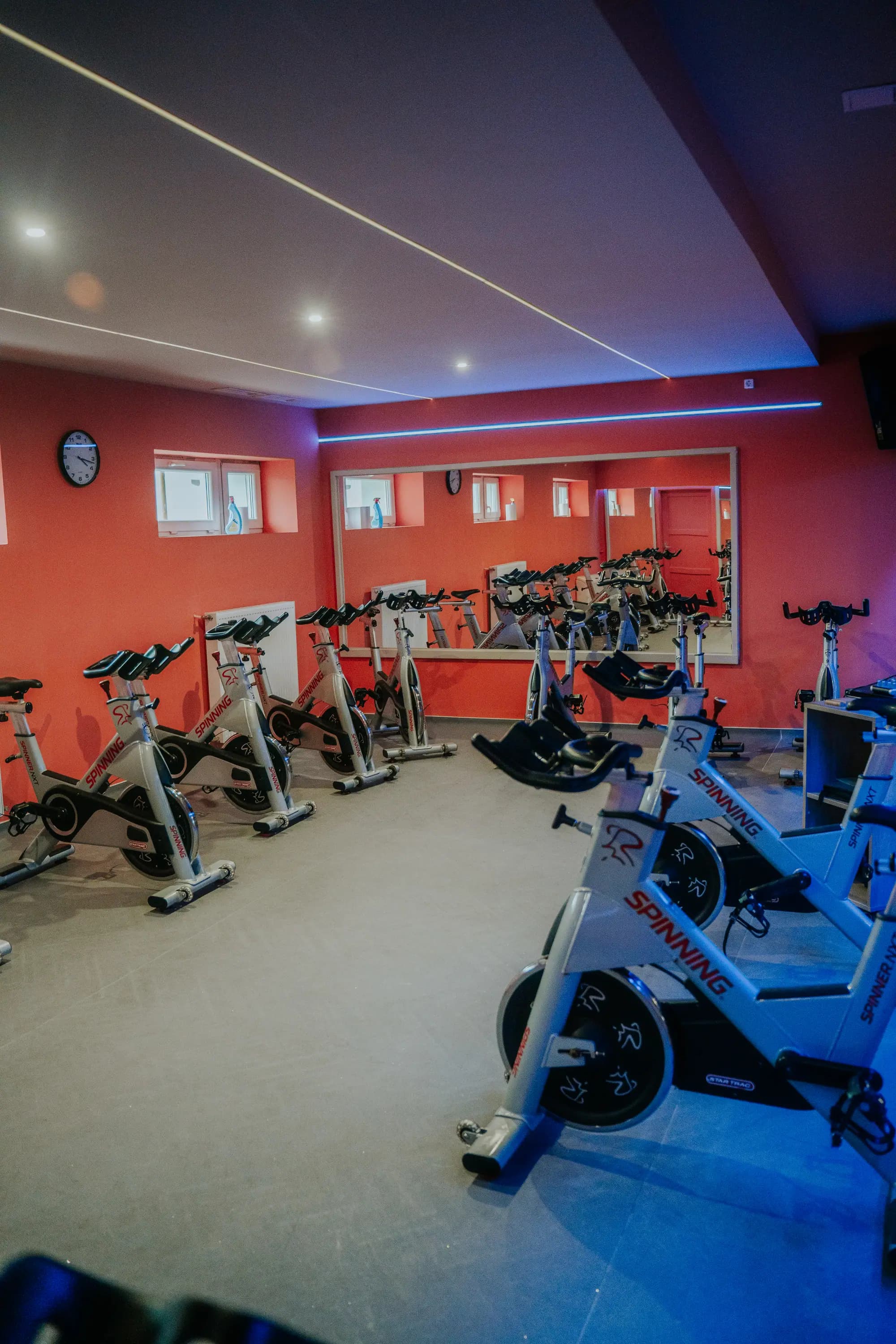 A spinning terem teljes nézete kerékpárokkal, tükörfallal és LED-világítással